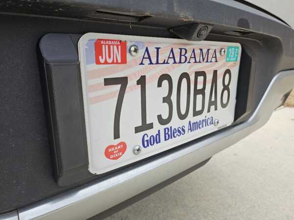 Closeup of the license plate tool holder (LPTH) set installed on a Rivian R1T with no license plate frame.