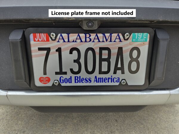 Closeup front view of the license plate tool holder (LPTH) set installed on a Rivian R1T with a simple black license plate frame (not included) installed.